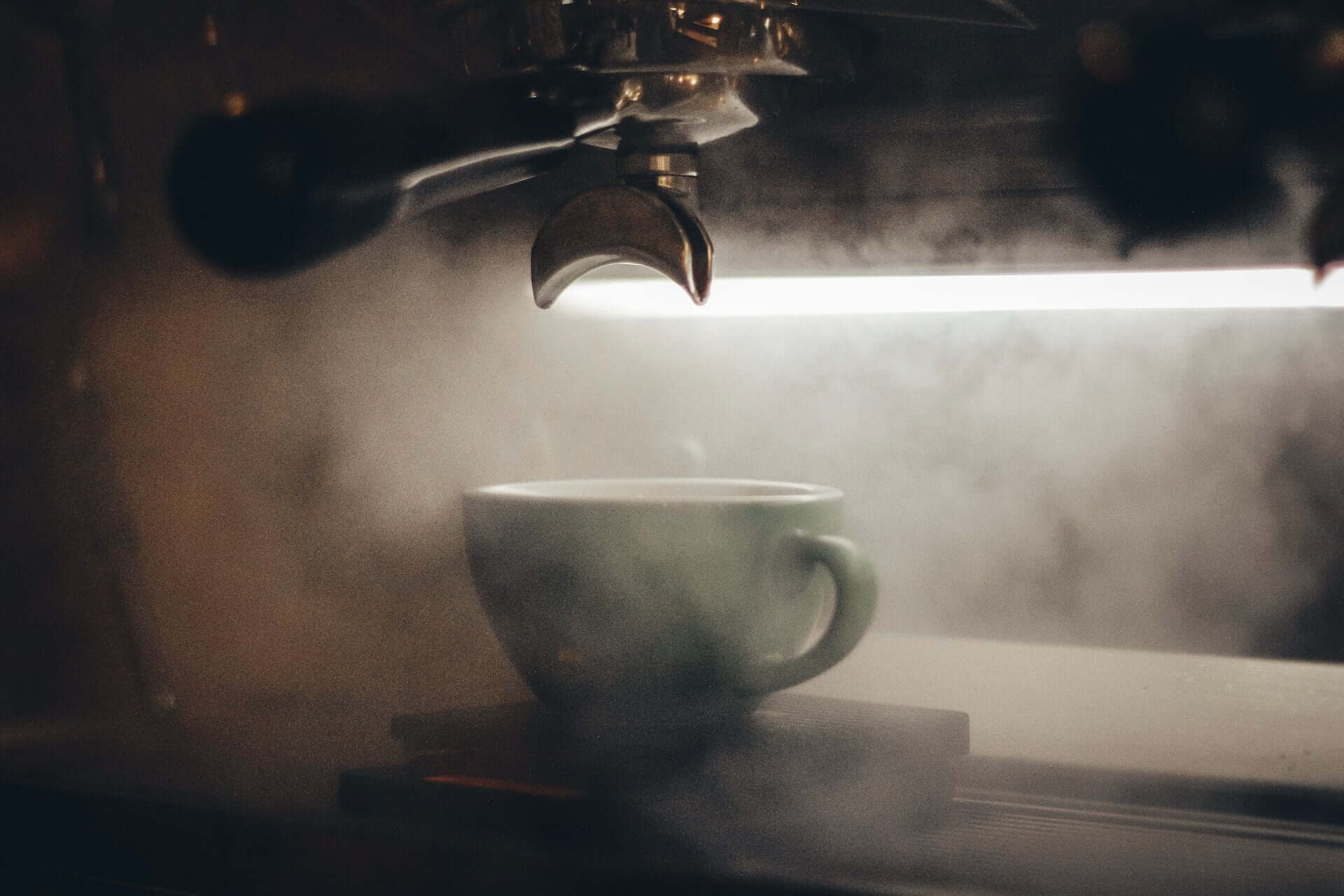 Espresso makinesi altında buharla kaplı Rainwater kahve fincanı.